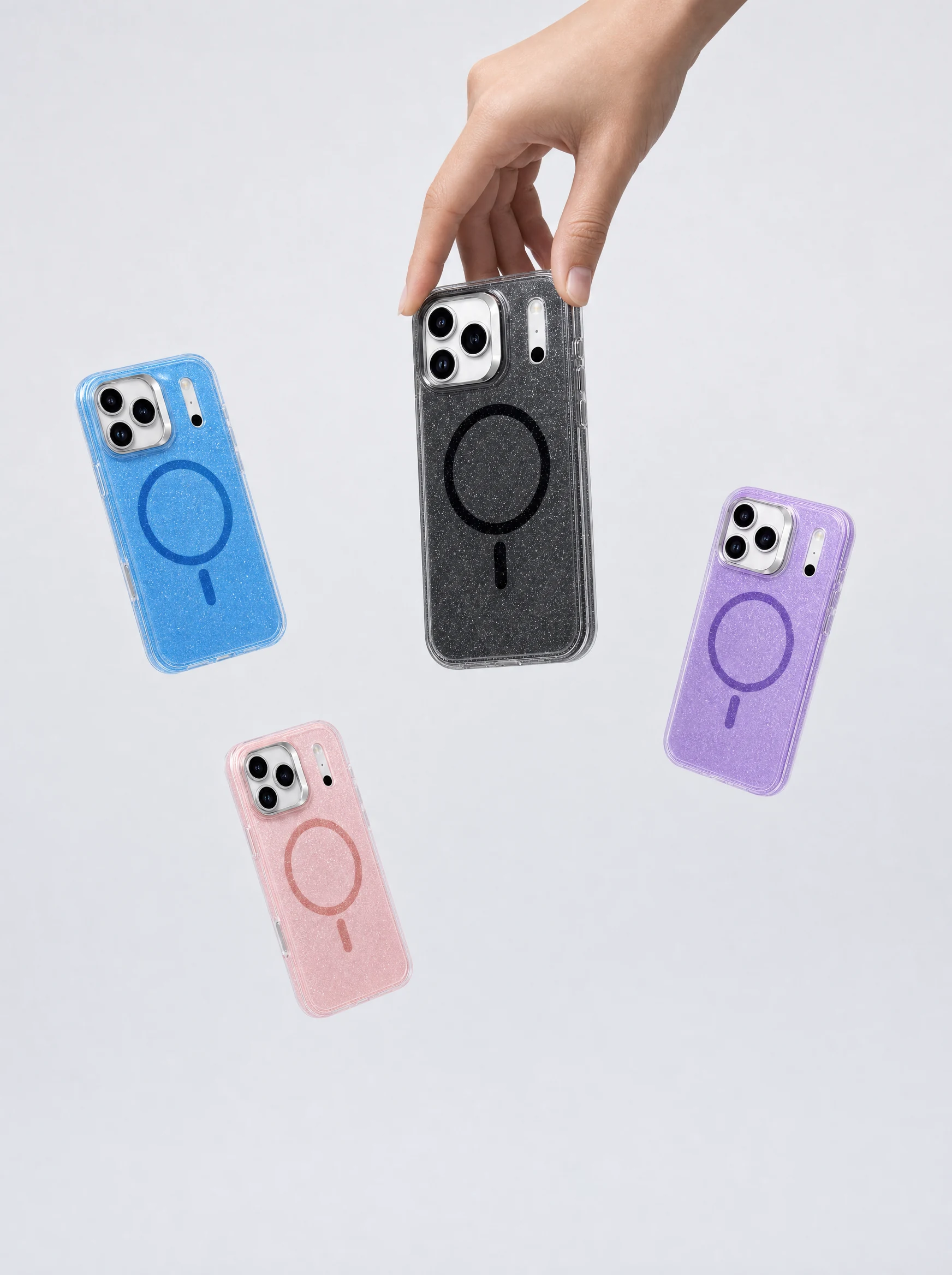 A hand holds the black glitter MagSafe iPhone case above falling blue, pink and purple glitter cases, portrait composition